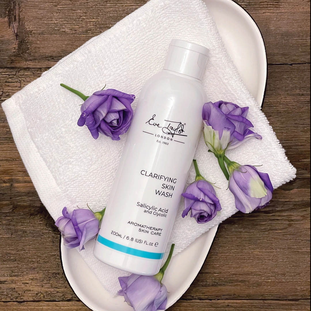 Eve Taylor Clarifying Skin Wash on white towel with purple flowers